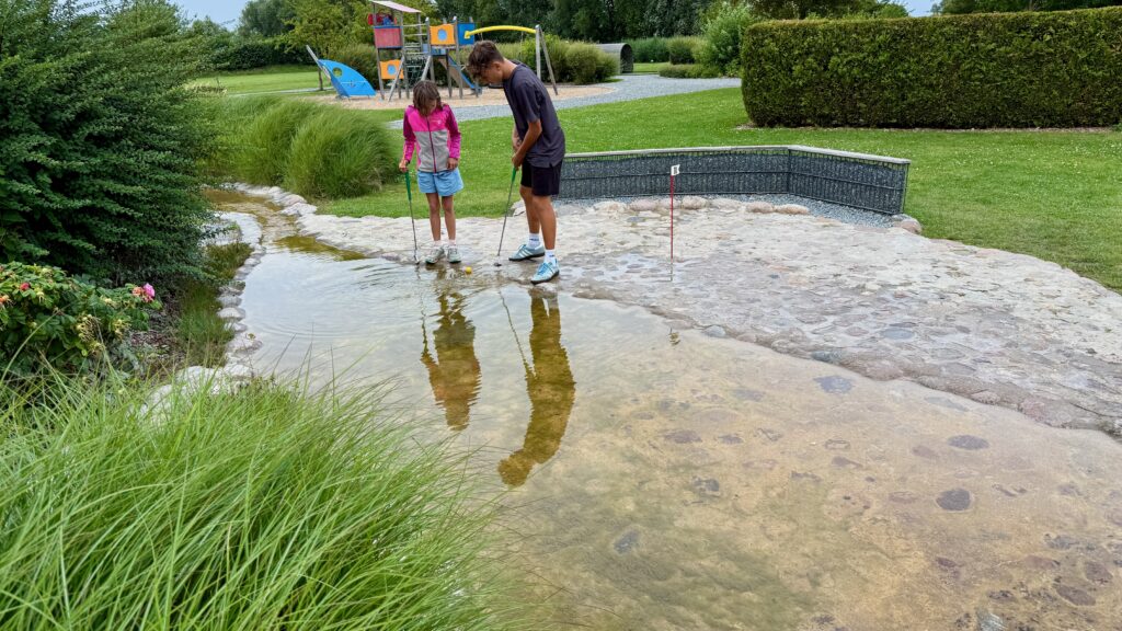 Minigolf Station mit einem kleinen, künstlichen Bachlauf als Hindernis